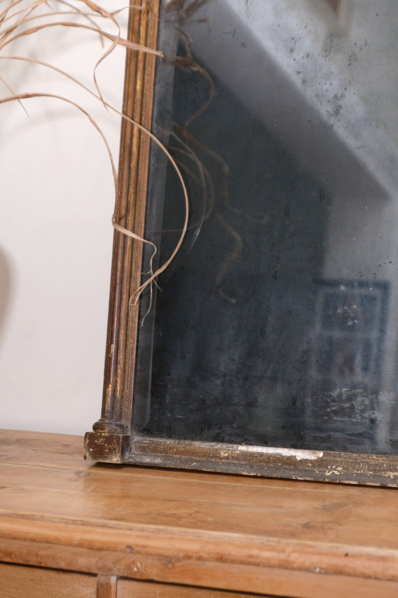Close‑up of original foxed glass on antique gilt pier mirror