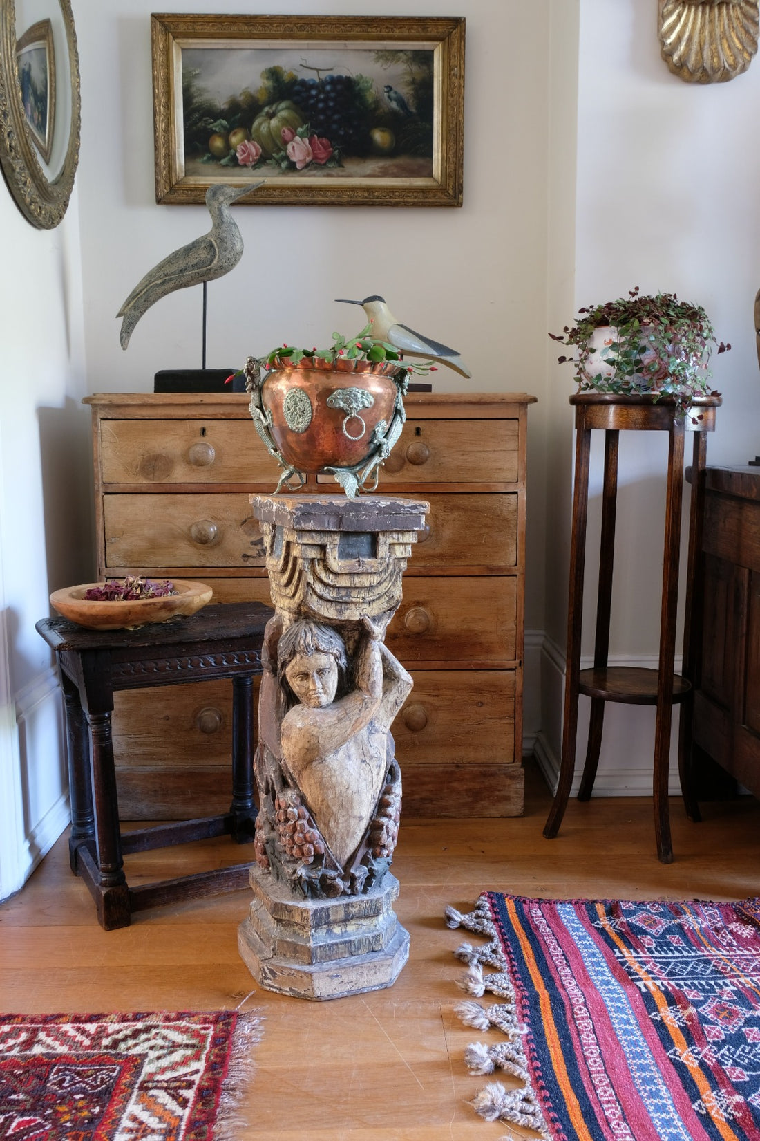 19th-century carved polychrome putto pedestal sculpture with grape motif