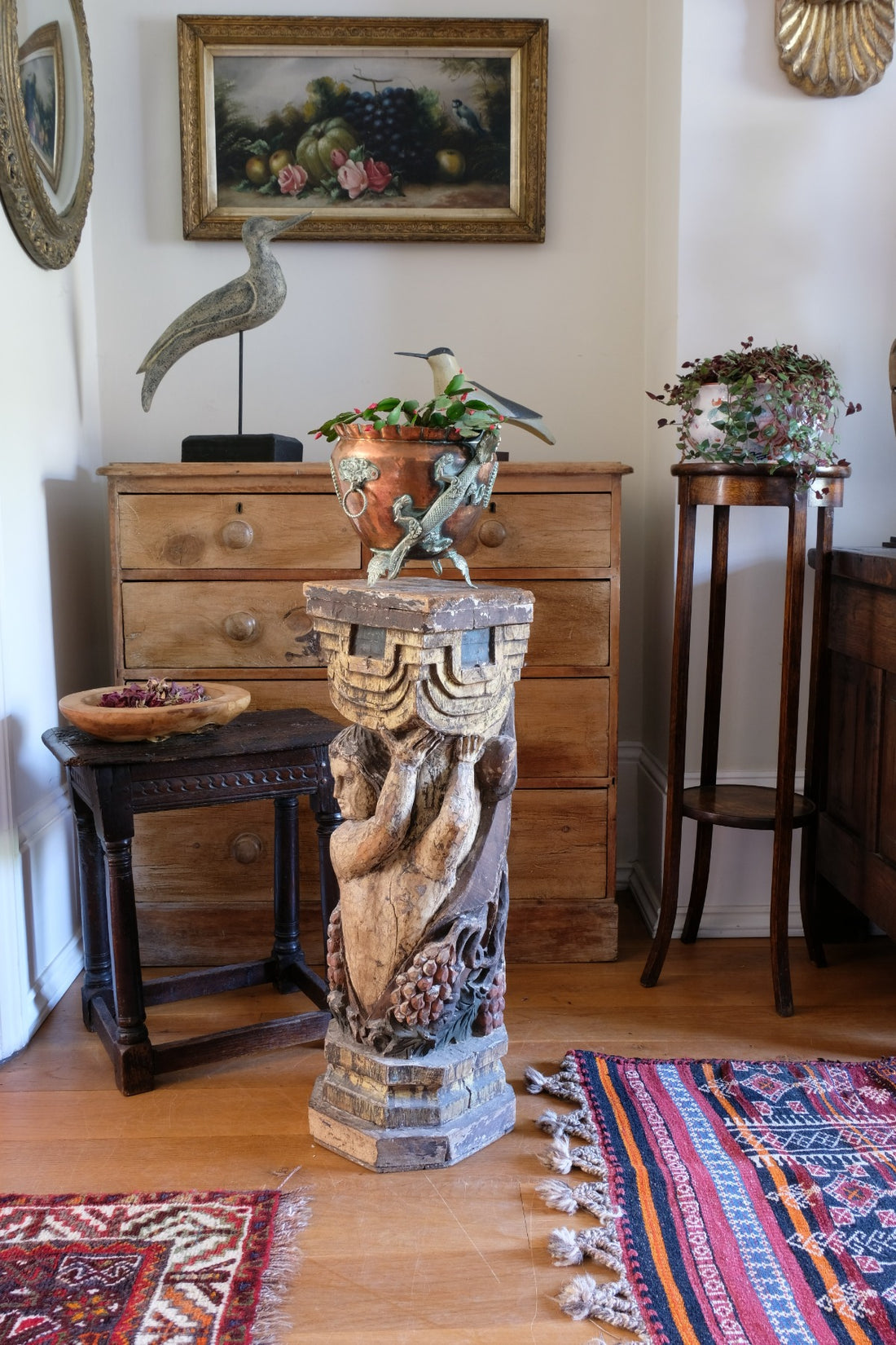 19th-century carved polychrome putto pedestal sculpture with grape motif