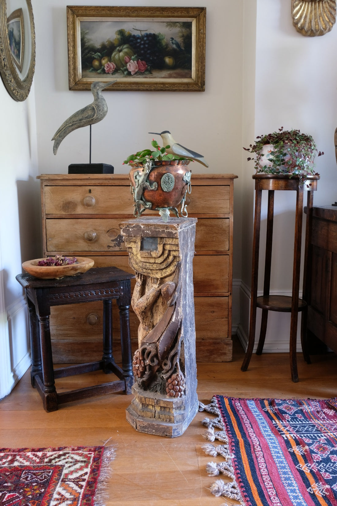 19th-century carved polychrome putto pedestal sculpture with grape motif