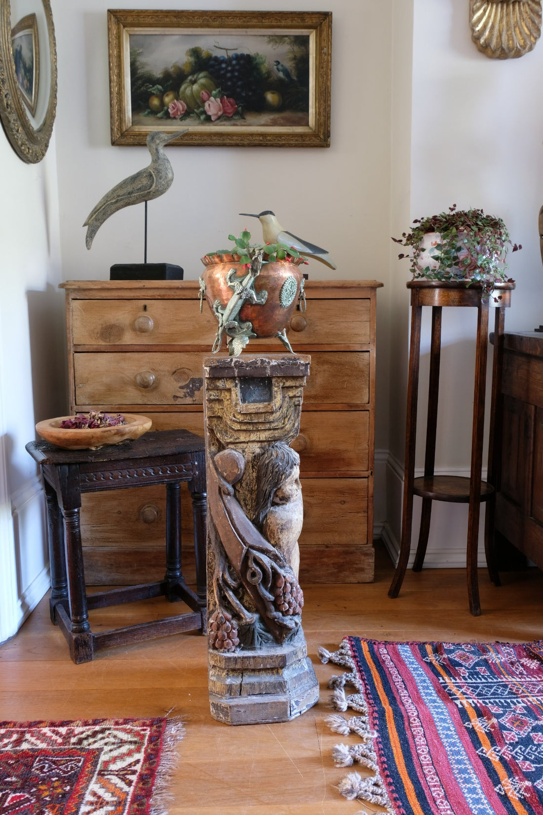 19th-century carved polychrome putto pedestal sculpture with grape motif