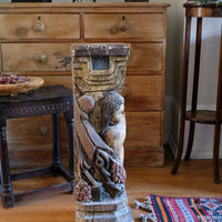 19th-century carved polychrome putto pedestal sculpture with grape motif