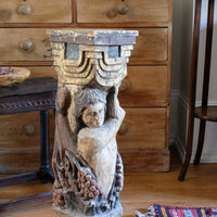 Antique carved polychrome putto pedestal with aged patina