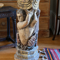 19th-century carved polychrome putto pedestal sculpture with grape motif