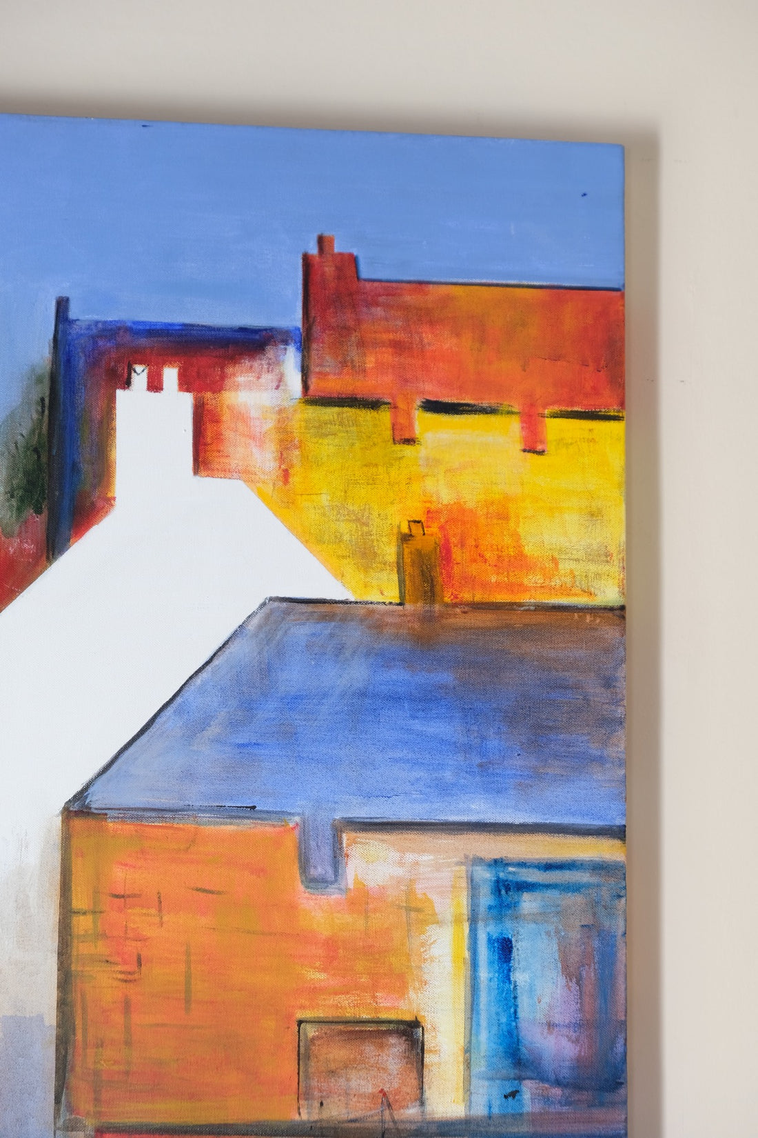 Abstract painting of a house with bold colors on a wall.