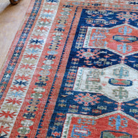 Handwoven Caucasus Kazak wool rug with shield medallions on blue ground