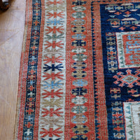 Kazak wool rug with shield kazak medallions - Traditional patterned rug on a wooden floor