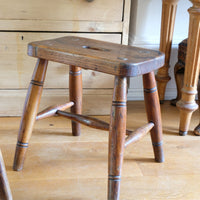 Antique elm and ash farmhouse stool with hand hole, circa 1860"
"Rustic 19th century wooden stool with turned baluster legs