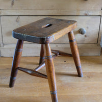 Antique elm and ash farmhouse stool with hand hole, circa 1860"
"Rustic 19th century wooden stool with turned baluster legs