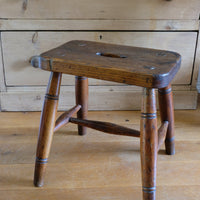 Antique elm and ash farmhouse stool with hand hole, circa 1860"
"Rustic 19th century wooden stool with turned baluster legs