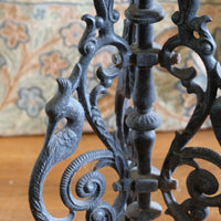 Close-up of a detailed wrought iron object with a patterned fabric background
