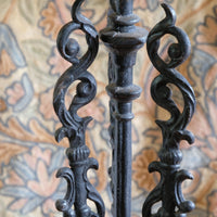 Decorative black metal table with intricate designs against a patterned background