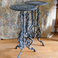 Decorative cast iron table with intricate designs on a wooden floor.