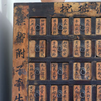 Close-up of antique Chinese storage drawers with hand-painted calligraphy