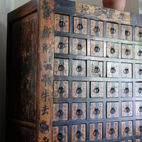 Detail of hand-painted Chinese calligraphy on antique wooden drawers