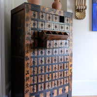 Detail of hand-painted Chinese calligraphy on antique wooden drawers