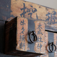 Close-up of antique Chinese storage drawers with hand-painted calligraphy