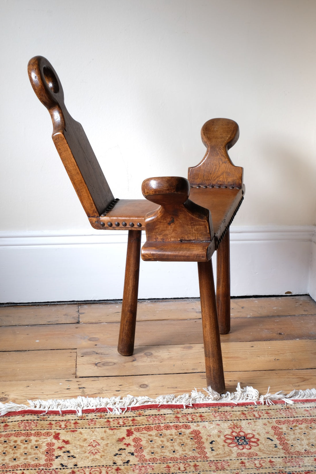 Side profile with sculptural arms and tripod base