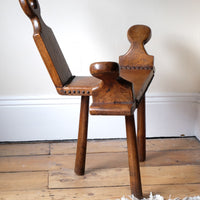 Side profile with sculptural arms and tripod base