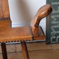 Detail of aged studded leather seat and patina