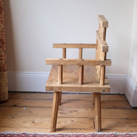 side view - Primitive handmade wooden armchair with rustic timber finish and blocky carved design