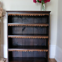 Edwardian carved oak bookcase with leather dust cover fringes