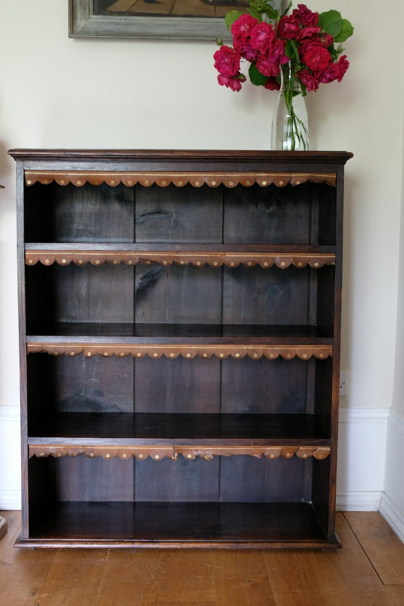 Edwardian carved oak bookcase with leather dust cover fringes