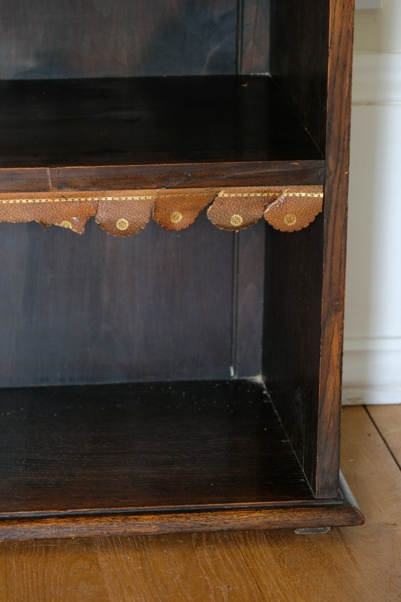 Edwardian carved oak bookcase with leather dust cover fringes