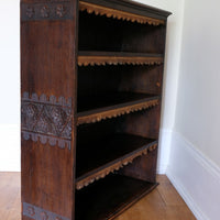 Edwardian carved oak bookcase with leather dust cover fringes
