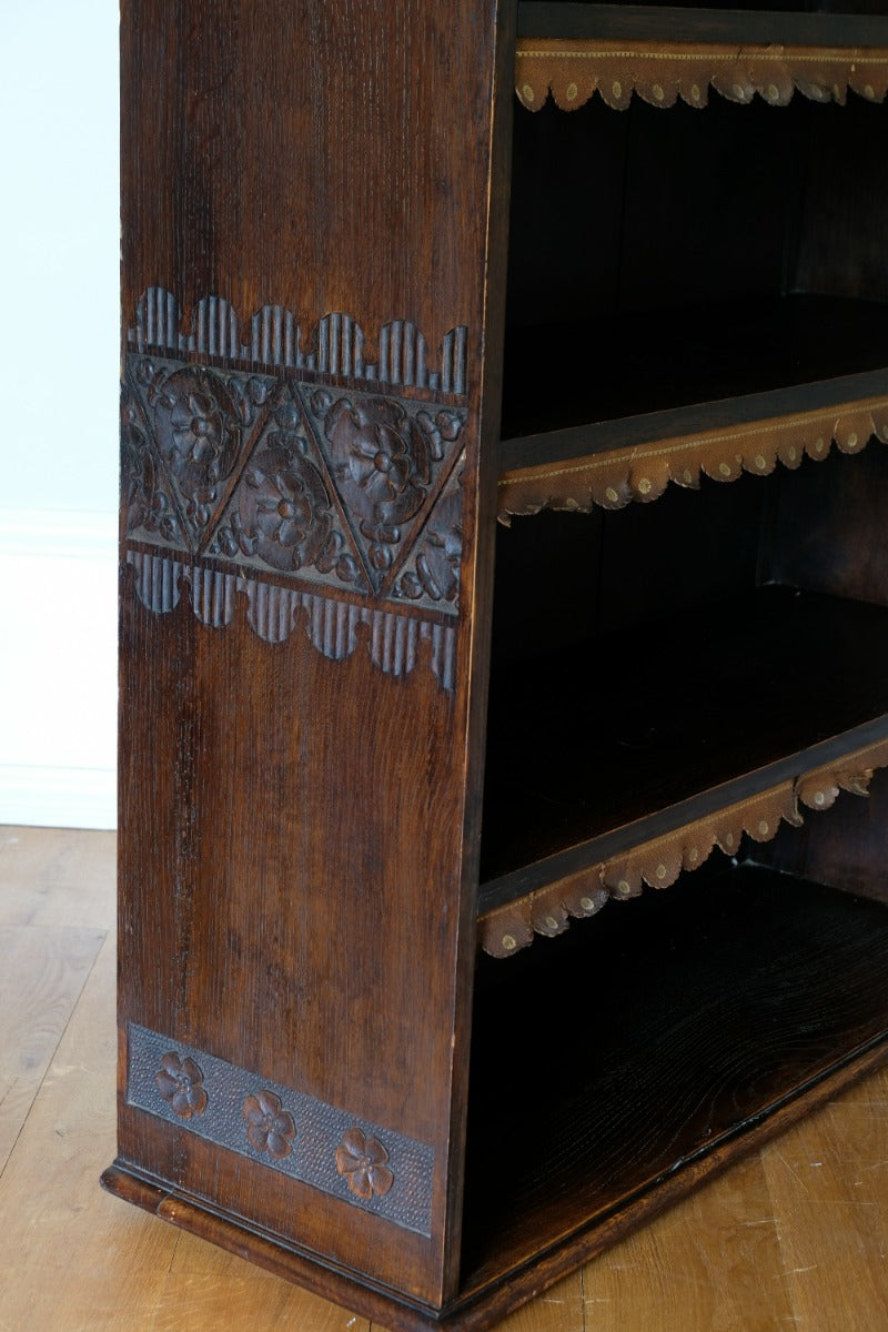 Edwardian carved oak bookcase with leather dust cover fringes