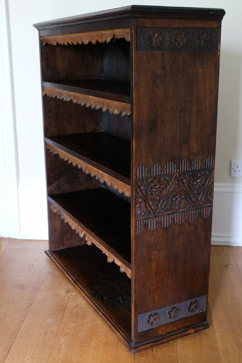 Edwardian carved oak bookcase with leather dust cover fringes