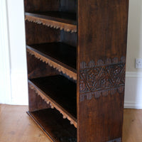 Edwardian carved oak bookcase with leather dust cover fringes