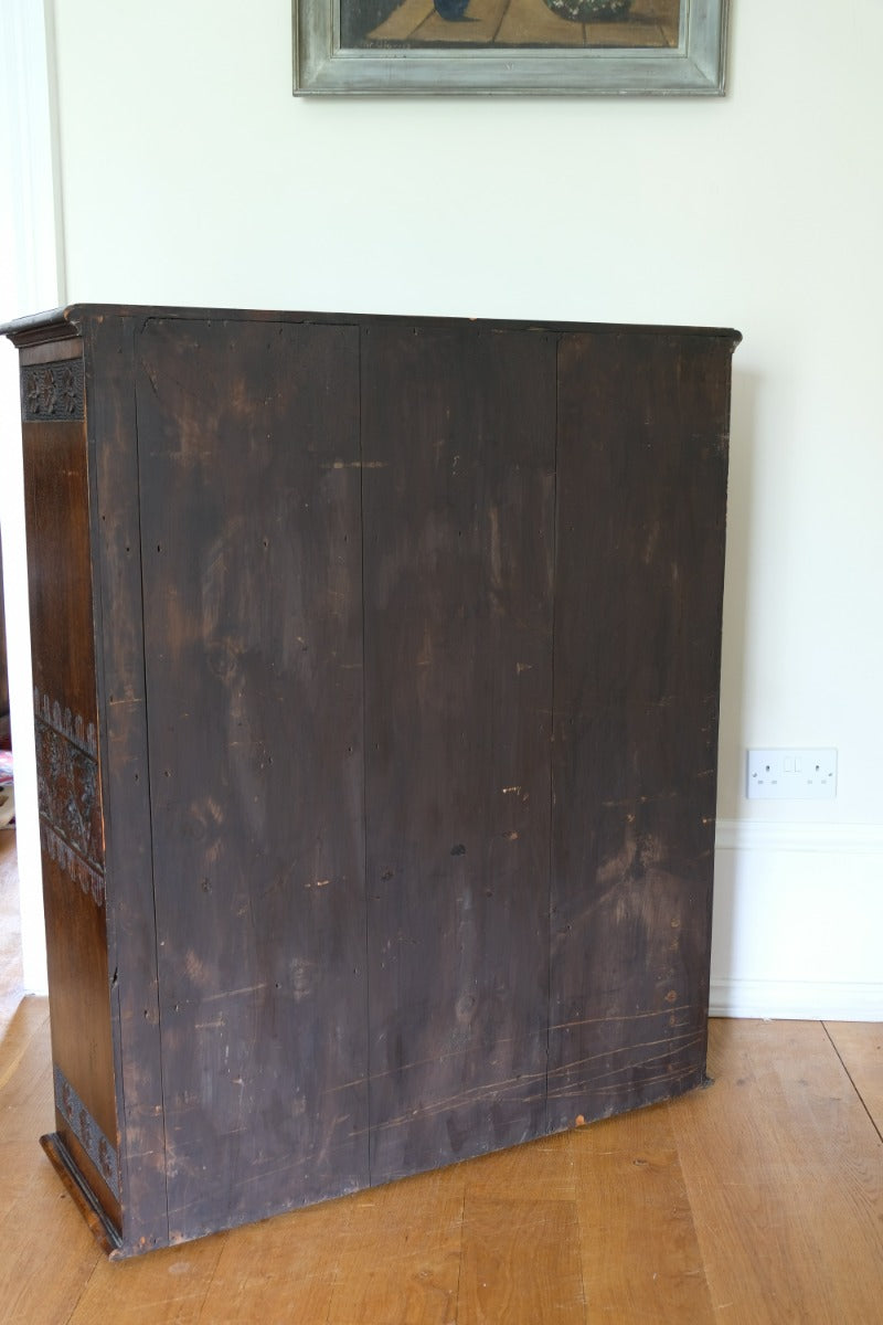 back of the Edwardian carved oak bookcase with leather dust cover fringes