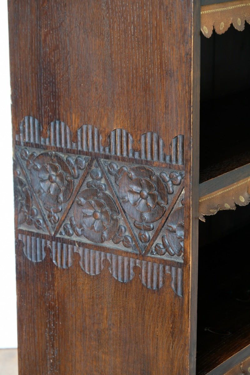 Detail of floral carved side panel on Arts and Crafts bookcase