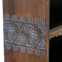 Detail of floral carved side panel on Arts and Crafts bookcase