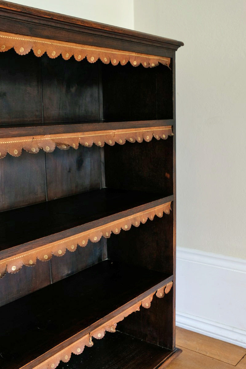 Edwardian carved oak bookcase with leather dust cover fringes