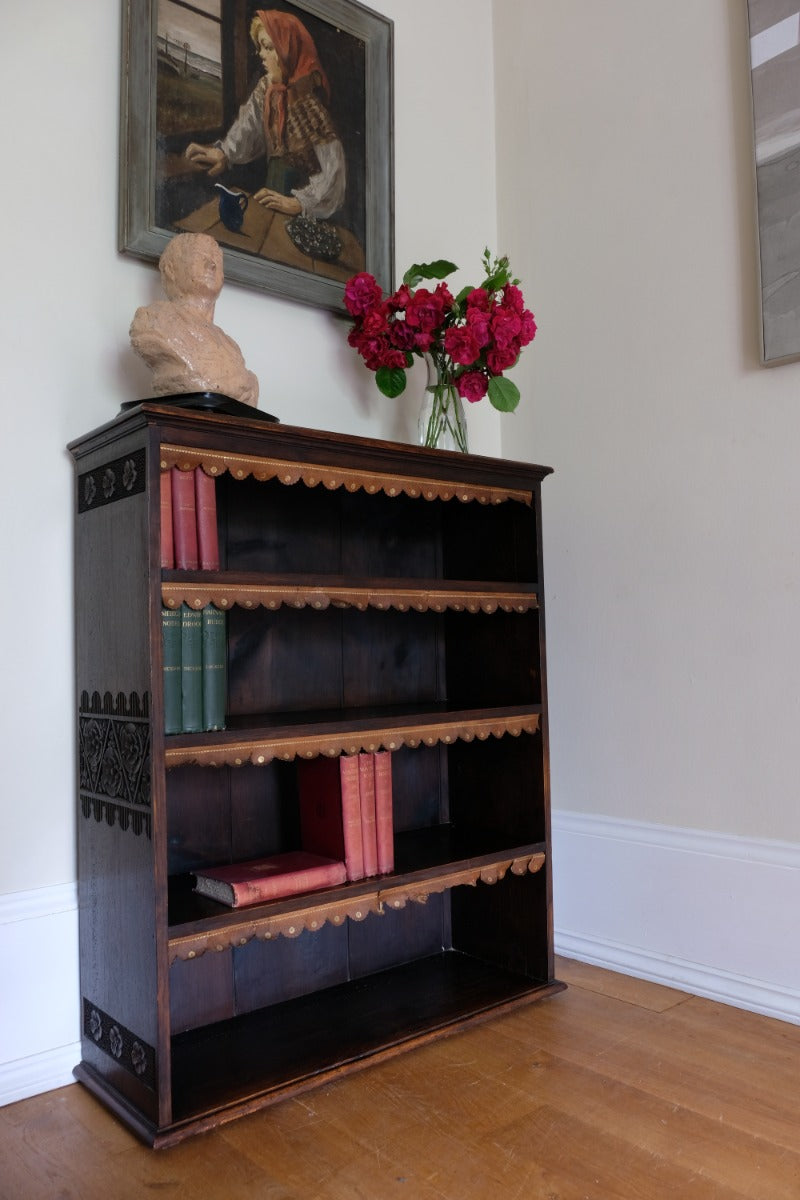 Edwardian carved oak bookcase with leather dust cover fringes