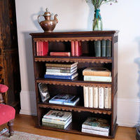 Edwardian Arts and Crafts carved oak bookcase with original tooled leather dust fringing shelves