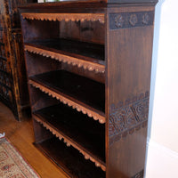 close up view of side view detail of carved arts & crafts end panels - Edwardian Arts and Crafts carved oak bookcase with original tooled leather dust fringing shelves