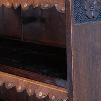 close-up leather fringes on a Edwardian Arts and Crafts carved oak bookcase with original tooled leather dust fringing shelves