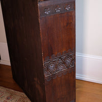 Other side view of a Edwardian Arts and Crafts carved oak bookcase with original tooled leather dust fringing shelves