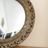 19th century round convex mirror with pierced giltwood frame and aged gilt finish