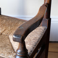 Serpentine arm on an Antique Lancashire Oak Spindle Back Armchair with Rush Seat, 19th Century North Country Chair