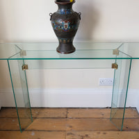 Top view - Modern glass hall table with sculptural metal V-shaped base in Leon Rosen style