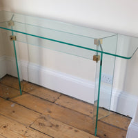 Modern glass hall table with sculptural metal V-shaped base in Leon Rosen style