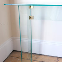 close up of precision-engineered angled joints - Modern glass hall table with sculptural metal V-shaped base in Leon Rosen style