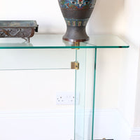 Modern glass hall table with sculptural metal V-shaped base in Leon Rosen style