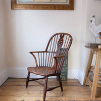 Antique English Windsor armchair in elm with uneven seat and ash stick back