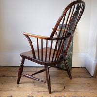 Antique English Windsor armchair in elm with uneven seat and ash stick back