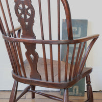 Antique English Windsor armchair in elm with uneven seat and ash stick back
